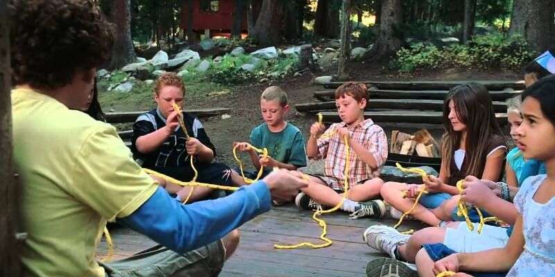 children tying knots in yellow rope