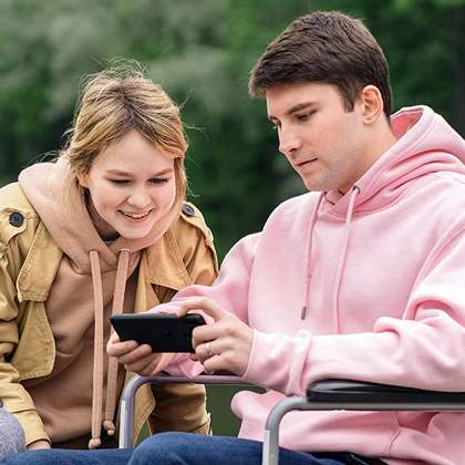 Couple looks at mobile phone outdoors